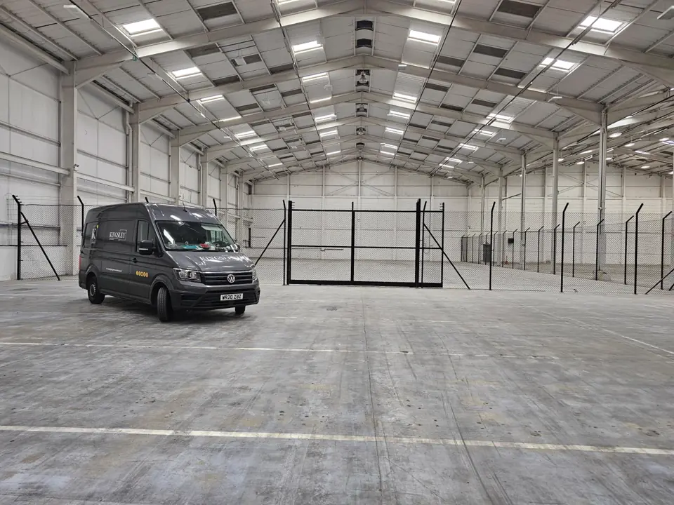 Black welded-mesh security partitioning and gates inside a Newport warehouse